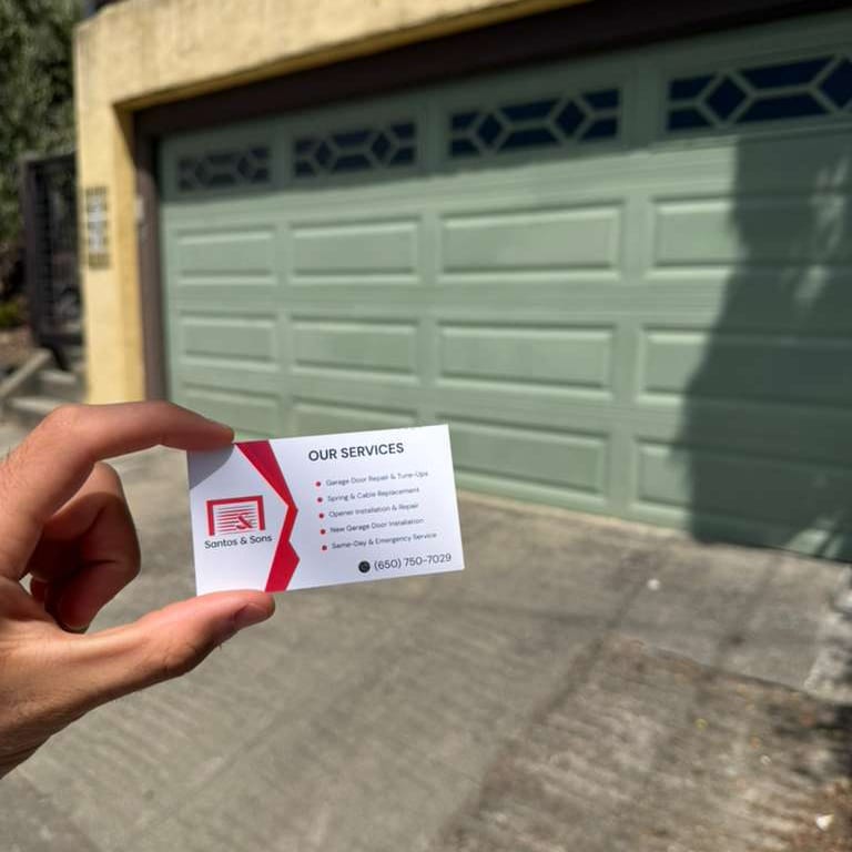 Santos & Sons business card at a garage door repair job in Berkeley, CA
