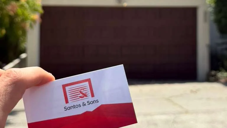 Santos & Sons business card in front of a new garage door in Berkeley, CA